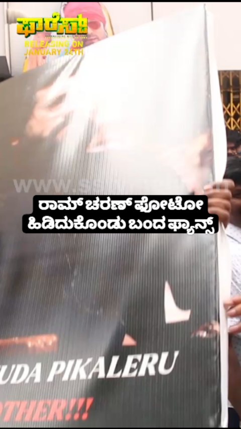 Fans holding Ram Charan's photo